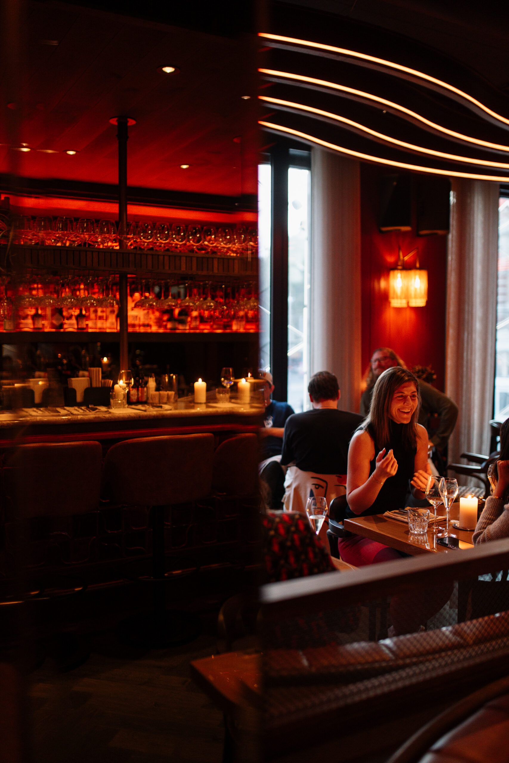 The red-lit bar with guests at tables in the evening