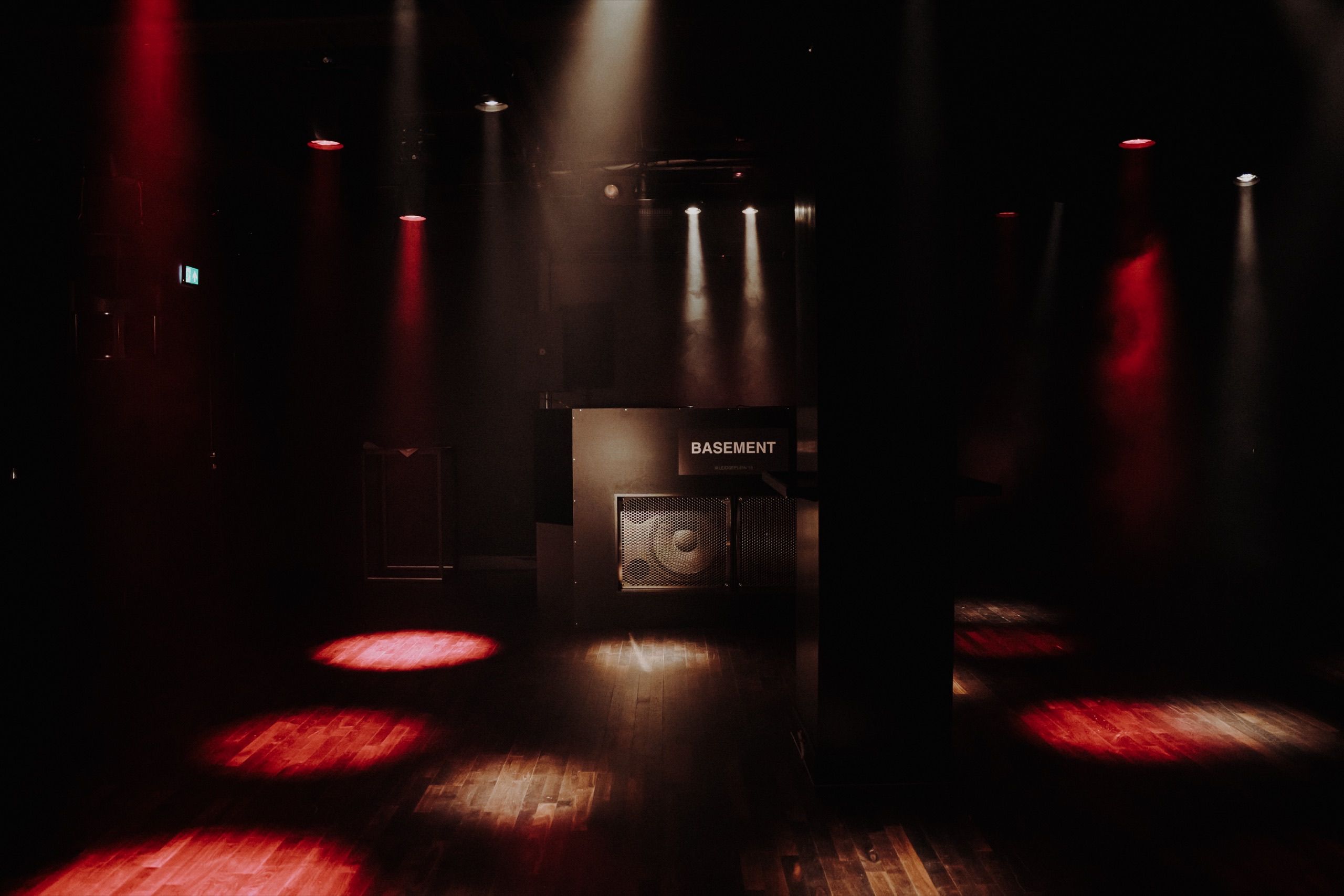 De dj-booth van Basement onder rode en witte spots